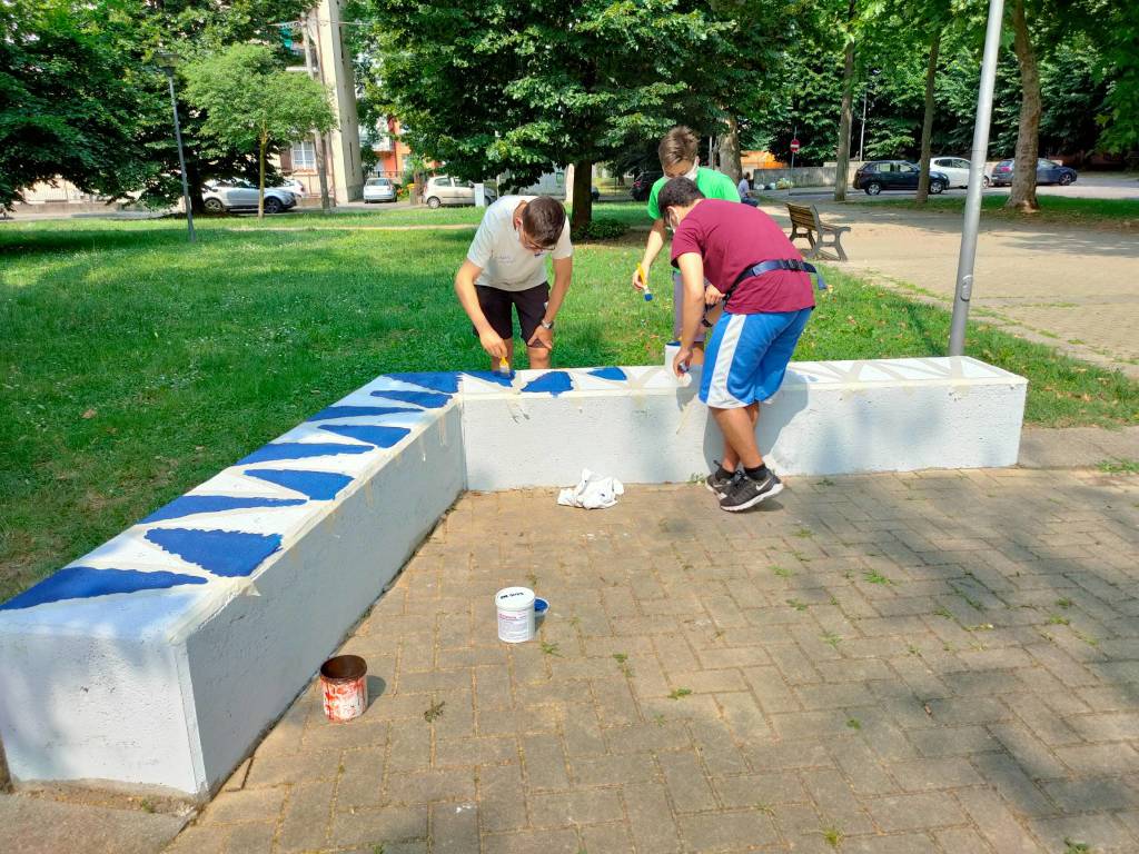 Giovani saronnesi al lavoro per dipingere le panchine del Matteotti 