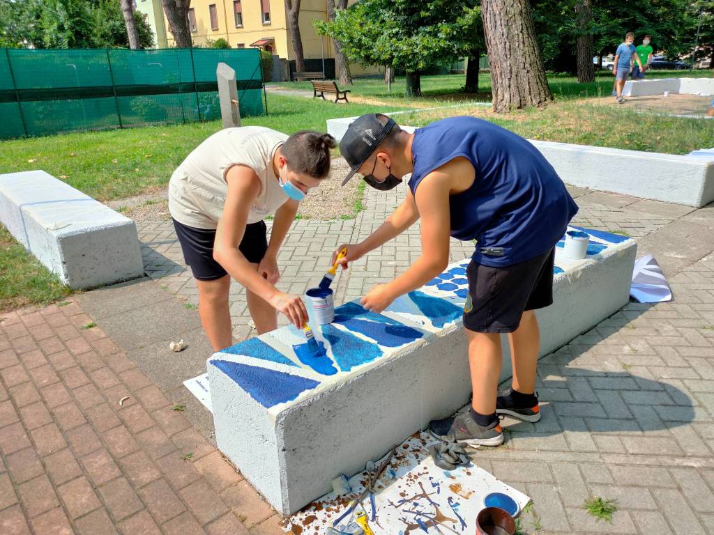 Giovani saronnesi al lavoro per dipingere le panchine del Matteotti 